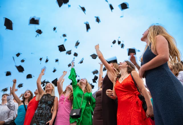 Graduates throwing their caps in the air