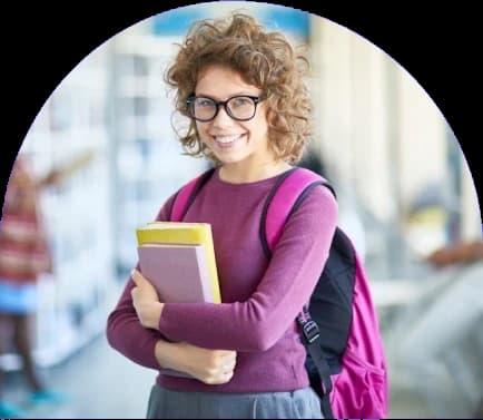 A student on campus holding her notebooks